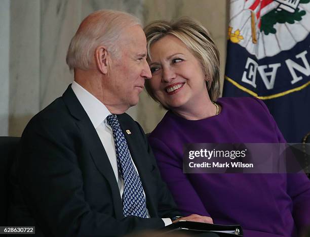 Former US Secretary of State, Hillary Clinton shares a laugh with US Vice President Joseph Biden, during a portrait unveiling ceremony for outgoing...