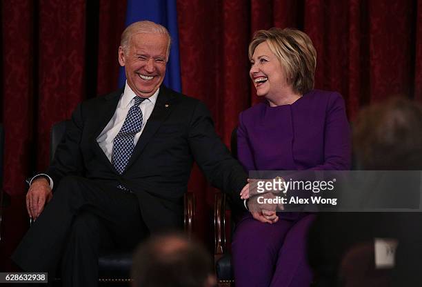 Former U.S. Secretary of State Hillary Clinton shares a moment with Vice President Joseph Biden during a leadership portrait unveiling ceremony for...