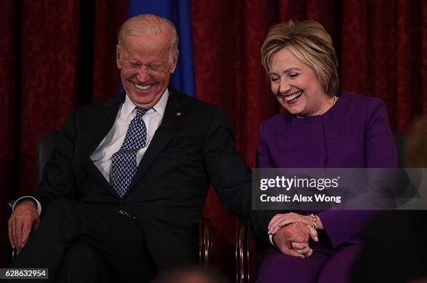 Former U.S. Secretary of State Hillary Clinton shares a moment with Vice President Joseph Biden during a leadership portrait unveiling ceremony for...