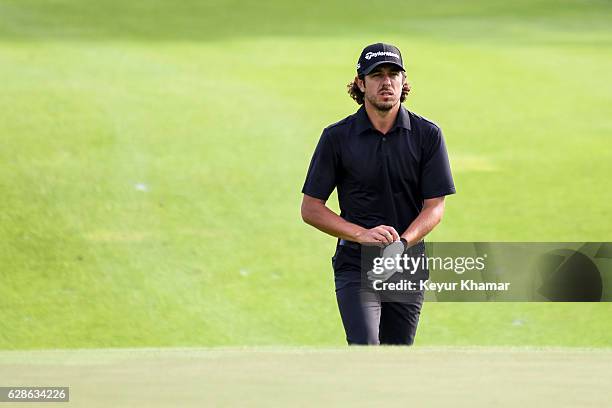 Puma Emilio Dominguez of Argentina puts on his glove as he walks to the 18th hole green during the first round of Web.com Tour Q-School on the...