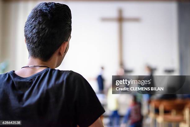 Iranian refugee Kazem visits a course preparing him to convert into christian confession by baptism in Berlin, on October 23, 2016. / AFP / CLEMENS...