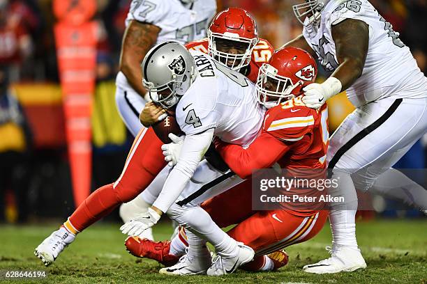 Quarterback Derek Carr of the Oakland Raiders is sacked by defensive tackle Rakeem Nunez-Roches of the Kansas City Chiefs at Arrowhead Stadium during...