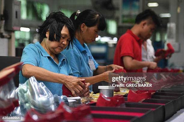 This photo taken on September 14, 2016 shows workers on a production line at the Huajian shoe factory in Dongguan, in south China's Guangdong...