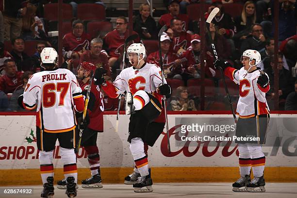 Dougie Hamilton of the Calgary Flames celebrates his game winning goal with Michael Frolik and Mikael Backlund against the Arizona Coyotes in...