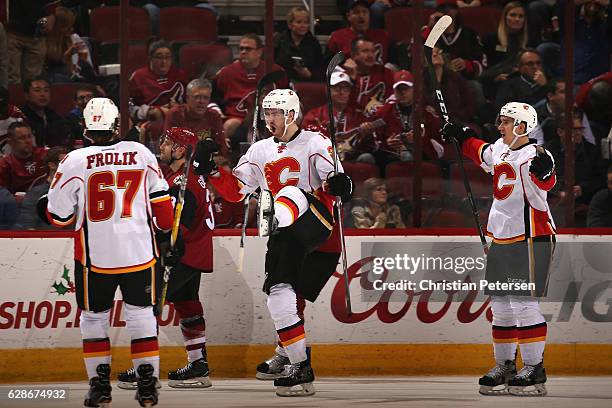 Dougie Hamilton of the Calgary Flames celebrates his game winning goal with Michael Frolik and Mikael Backlund against the Arizona Coyotes in...