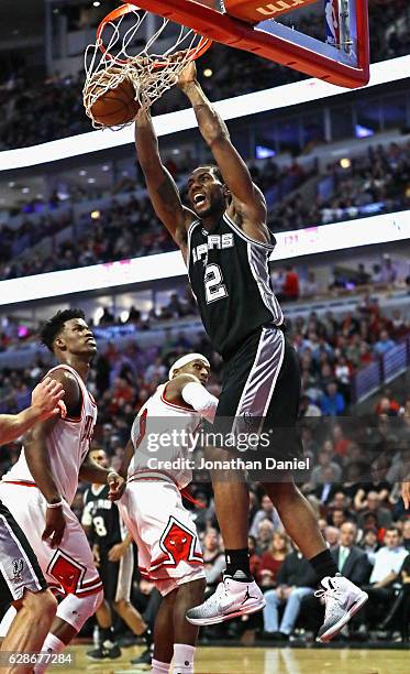 Kawhi Leonard of the San Antonio Spurs dunks over Jimmy Butler of the Chicago Bulls on his way to a game-high 24 points at the United Center on...