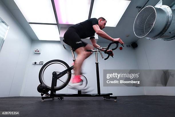 Cyclist rides a stationary bicycle to test out kit in 'The Vault', a climactic simulation chamber in the basement of the Rapha Racing Ltd. Cycle club...