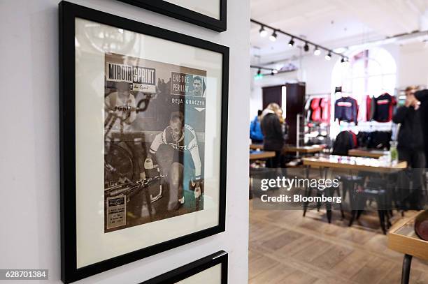 Framed cover of vintage cycling publication Miroir Sprint hangs on the wall at the Rapha Racing Ltd. Cycle club in Spitalfields market in London,...