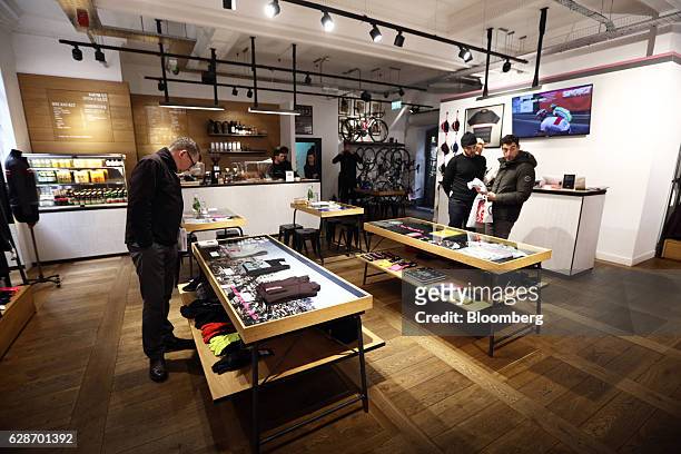 Customers browse clothing on display at the Rapha Racing Ltd. Cycle club in Spitalfields market in London, U.K., on Tuesday, Nov. 8, 2016. To keep...