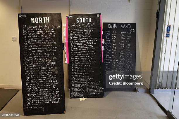 Chalkboards displaying the finish times of Manchester 2 London bicycle ride stand on display by the entrance of the Rapha Racing Ltd. Headquarters...