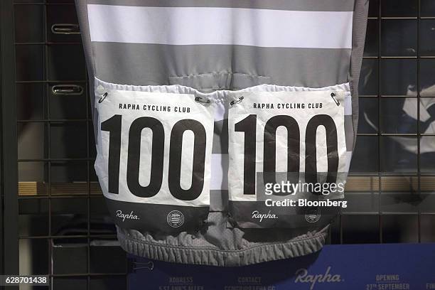 Race numbers sit pinned to the rear of a Rapha Cycle Club jersey as it hangs on display at the Rapha Racing Ltd. Headquarters office in London, U.K.,...