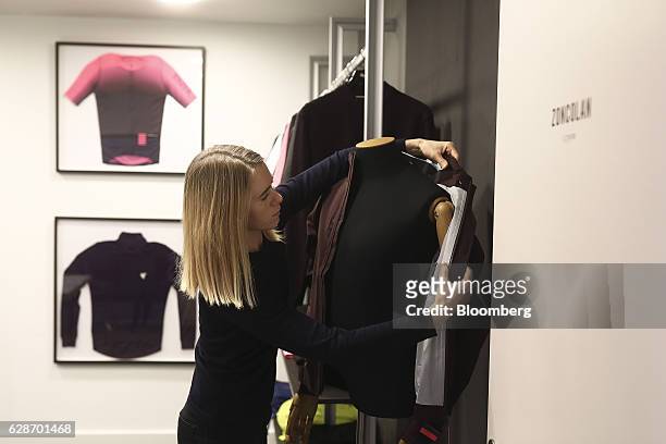 An employee adjusts a city rain jacket onto a display mannequin in a meeting room at the Rapha Racing Ltd. Headquarters office in London, U.K., on...
