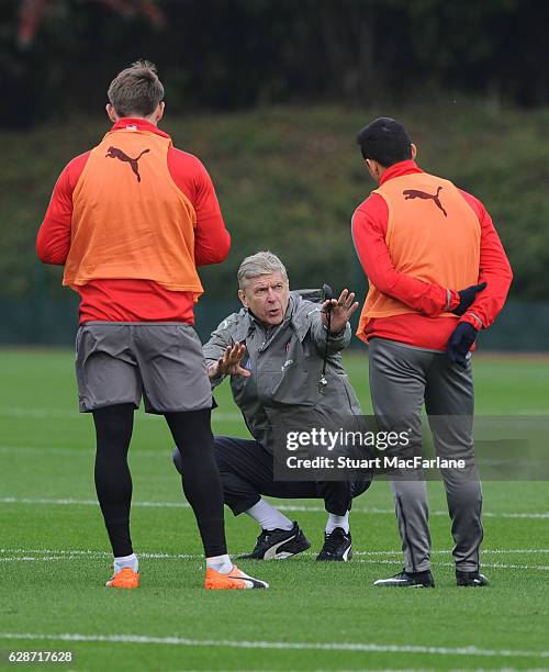 Arsenal manager Arsene Wenger talks to Nacho Monreal and Alexis Sanchez during a training session at London Colney on December 9, 2016 in St Albans,...