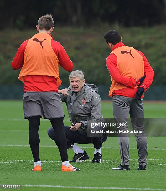 Arsenal manager Arsene Wenger talks to Nacho Monreal and Alexis Sanchez during a training session at London Colney on December 9, 2016 in St Albans,...