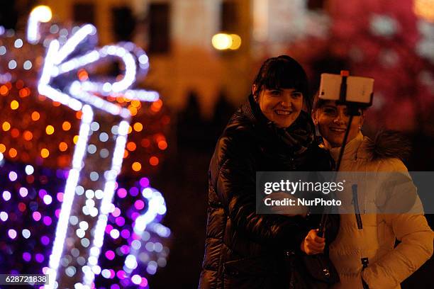 Bydgoszcz, December 8 2016. Two young women are seen taking selfies in front of a Christmas display on the old market square. Christmas spending is...