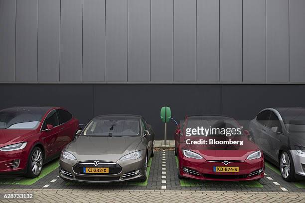 Tesla Model S, second left, and a Tesla Model 3 automobile, second right, stand by an electrical charging point outside the Tesla Motors Inc. Factory...