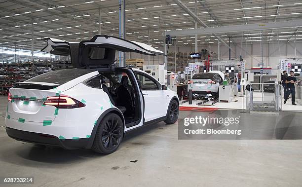 The rear gull wing doors of a Tesla Model X sports utility vehicle sit open during assembly for the European market at the Tesla Motors Inc. Factory...