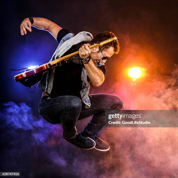 guitarist jumping on stage - músico de rock imagens e fotografias de stock
