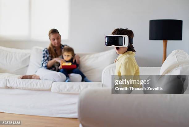 5 year old boy wearing virtual reality glasses - vr cardboard stock-fotos und bilder