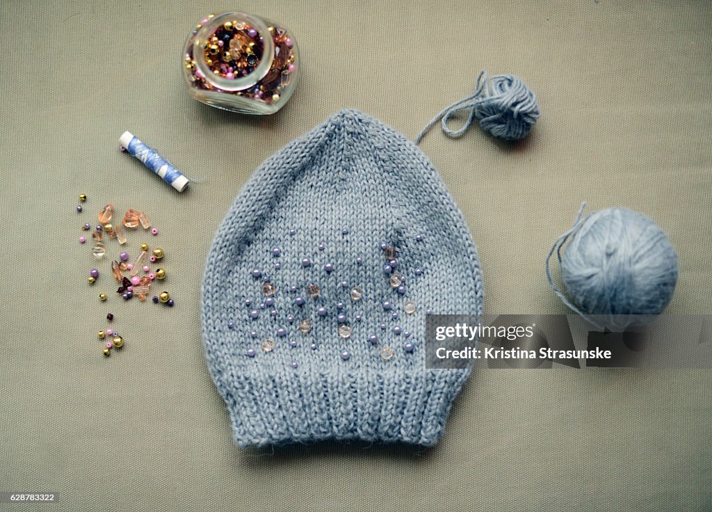 Knitted hat decorated with beads in matching colors