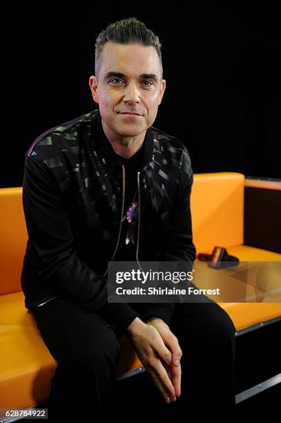 Robbie Williams poses backstage at Key 103 Christmas Live at Manchester Arena on December 9, 2016 in Manchester, England.