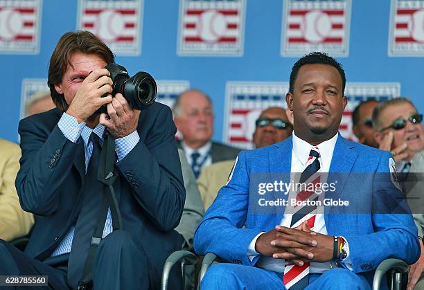 Hall of Fame inductee Randy Johnson, left, who is a serious photographer, has his camera with him on stage as he sits next to Pedro Martinez. Former...