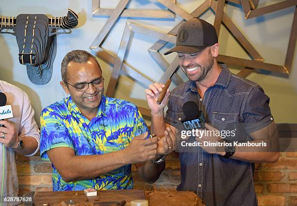 Orlando Jimenez and host Cody Alan participate in Rum Tasting and Cigar Rolling Event during CMT Story Behind The Songs LIV + Weekend Day 2 at...