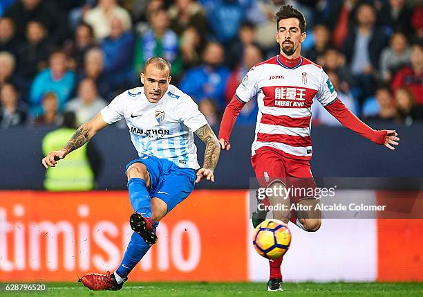 Sandro Ramirez of Malaga CF shoots while is being followed by Isaac Cuenca of Granada CF during La Liga match between Malaga CF and Granada CF at La...