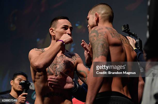 Opponents Max Holloway and Anthony Pettis face off during the UFC weigh-in at Air Canada Centre on December 9, 2016 in Toronto, Ontario, Canada.