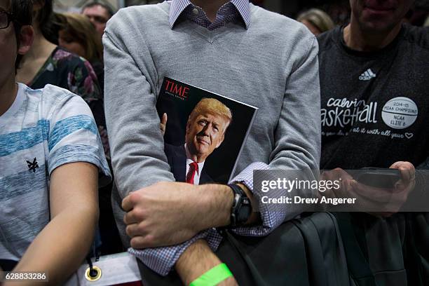 Member of the crowd holds a copy of TIME Magazine as President-elect Donald Trump speaks at the DeltaPlex Arena, December 9, 2016 in Grand Rapids,...