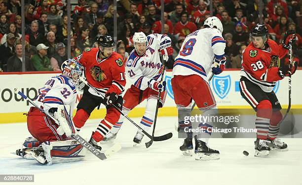 The Chicago Blackhawks' Ryan Hartman, right, tries to pass the puck against the New York Rangers defense in the first period at the United Center in...