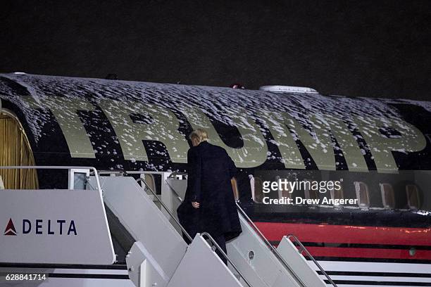 President-elect Donald Trump boards his snow-covered airplane at Gerald Ford International Airport, December 9, 2016 in Grand Rapids, Michigan....