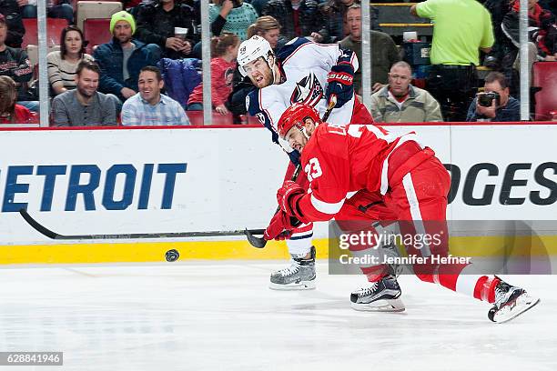 Brian Lashoff of the Detroit Red Wings gets his stick on the puck to block a shot by David Savard of the Columbus Blue Jackets during an NHL game at...