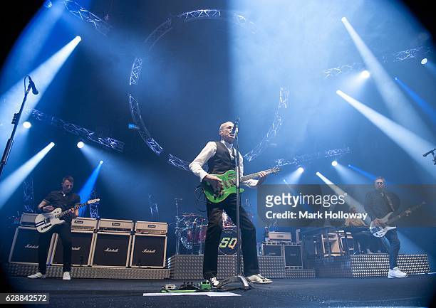 Freddie Edwards,Francis Rossi,John "Rhino" Edwards of Status Quo performing on stage at BIC on December 9, 2016 in Bournemouth, England.