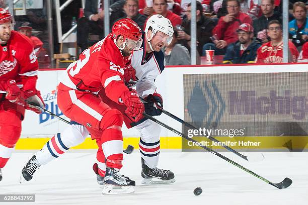 Brian Lashoff of the Detroit Red Wings and Scott Hartnell of the Columbus Blue Jackets battle for the puck during an NHL game at Joe Louis Arena on...