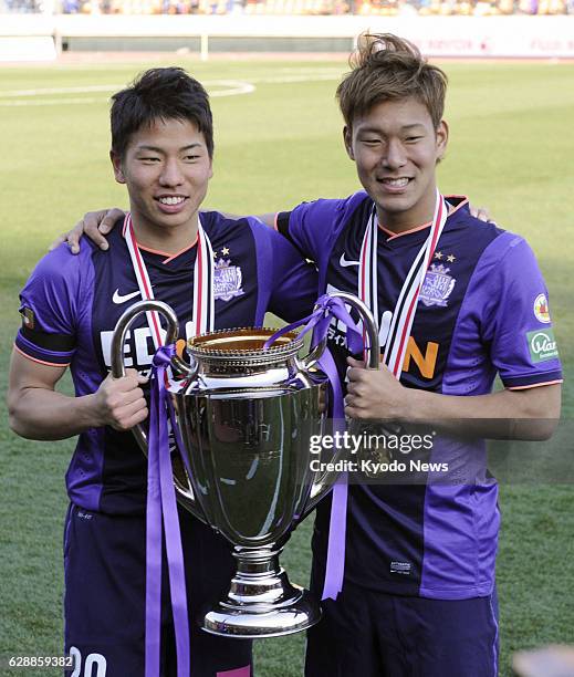 Japan - Takuma Asano and Gakuto Notsuda of Sanfrecce Hiroshima hold the Fuji Xerox Super Cup after a 2-0 victory over J-League Division 1 rivals...