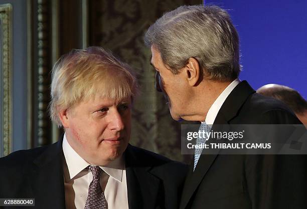 British Foreign Secretary Boris Johnson speaks with US Secretary of State John Kerry during a family picture prior to a meeting in Paris on December...