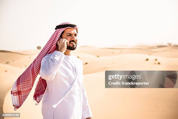 arabic sheik on the phone on the desert - middle eastern male on phone isolated stock pictures, royalty-free photos & images