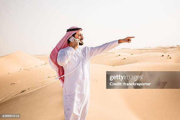 arabic sheik on the phone on the desert - middle eastern male on phone isolated stock pictures, royalty-free photos & images