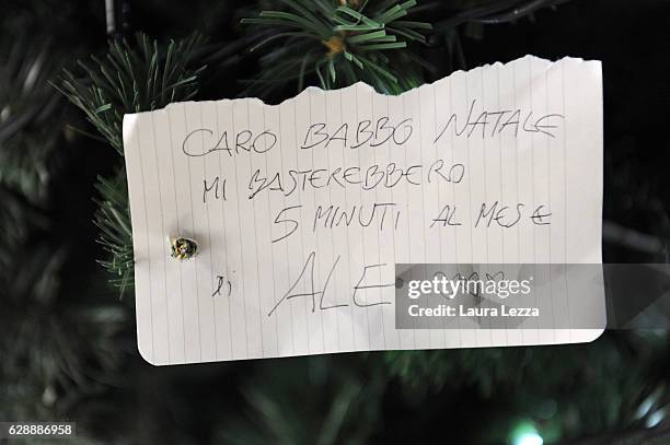 Christmas note that reads 'Caro Babbo Natale mi basterebbero 5 minuti al mese di Ale' is displayed on a Christmas tree at Santa Maria Novella train...