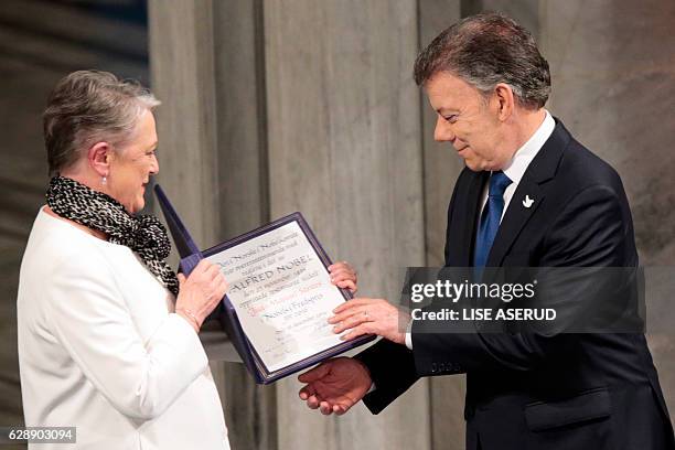 Nobel Peace Prize laureate Colombian President Juan Manuel Santos receives the medal and diploma from Norwegian Nobel Committee member Berit...