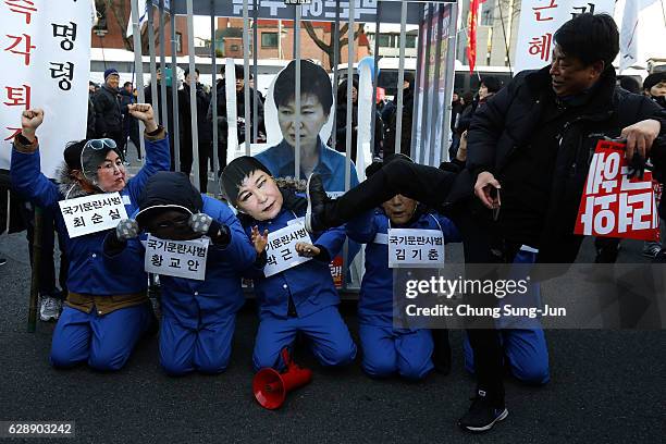 Protesters wearing masks of South Korea's President Park Geun-Hye and the president's long-time friend Choi Soon-Sil walk during a rally against...