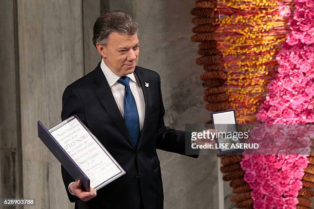 Nobel Peace Prize laureate Colombian President Juan Manuel Santos poses with the medal and diploma during the Peace Prize awarding ceremony at the...