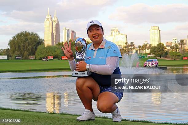 Shanshan Feng of China poses with her trophy after winning the final round of the 2016 Omega Dubai Ladies Masters at the Emirates Golf Club in Dubai...