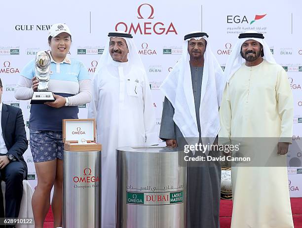 Shangshan Feng of China holds is presented with the trophy by His Highess Sheikh Hasher bin Maktoum bin Juma Al Maktoum the Director General of the...