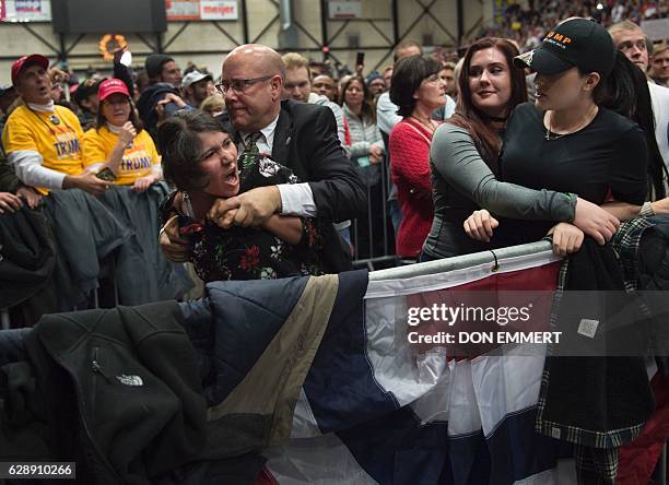 Protester is removed from the crowd of supporters as US President-elect Donald Trump speaks during the USA Thank You Tour December 9, 2016 in Grand...