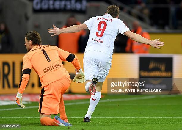 Cologne's Latvian striker Artjoms Rudnevs celebrates scoring the first goal as Dortmund's goalkeeper Roman Weidenfeller gets up during the German...