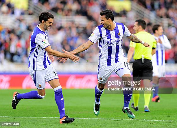 Real Sociedad's Brazilian forward Willian Jose is congratulated by teammate midfielder Xabier Prieto after scoring his team's second goal during the...