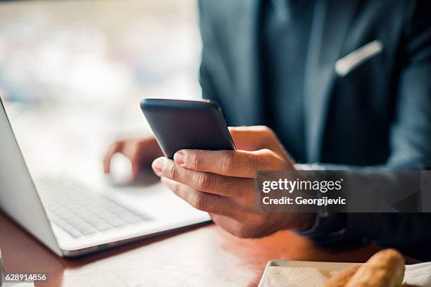 multitasking in the office - close up hand smart phone stock pictures, royalty-free photos & images