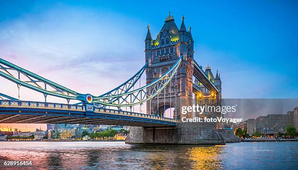 london tower bridge illuminated at sunset over river thames panorama - tower bridge imagens e fotografias de stock